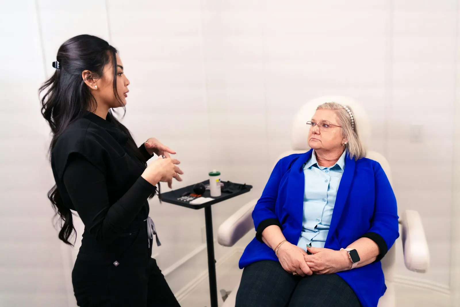 Una profesional conversa con una paciente sentada en la consulta